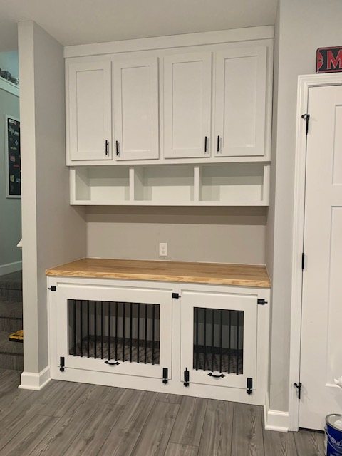 Built-in dog kennel cabinet with a butcher-block top and upper cabinets