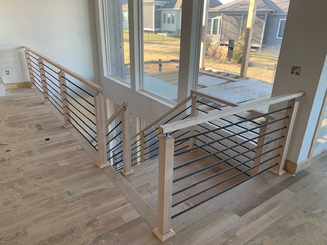 Loft railing with oak posts and horizontal black metal rails