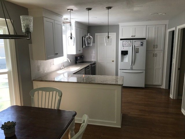 Kitchen remodel with white cabinets, stone counters and pendant lights