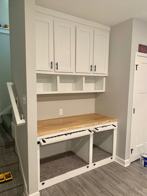Mudroom built-in with upper cabinets, cubbies and a butcher-block bench