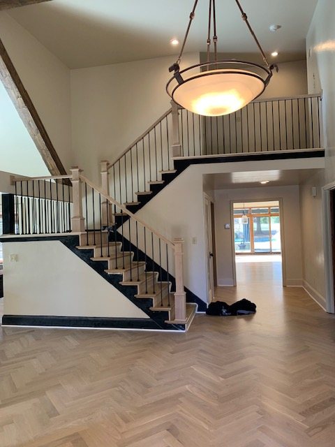 Switchback staircase with iron balusters seen from the upper landing